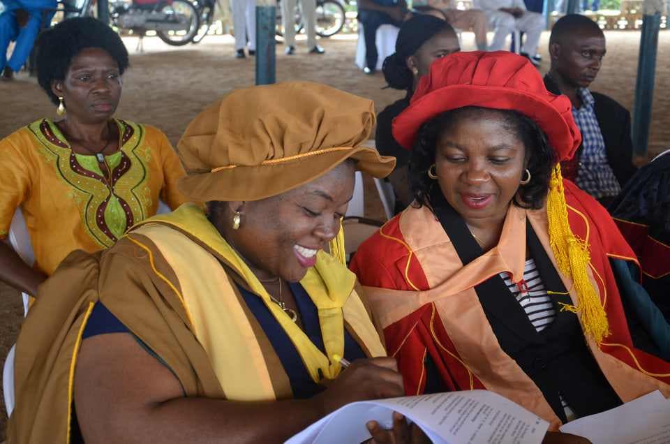 University officials in academic regalia reviewing matriculation documents at a MOAUM ceremony